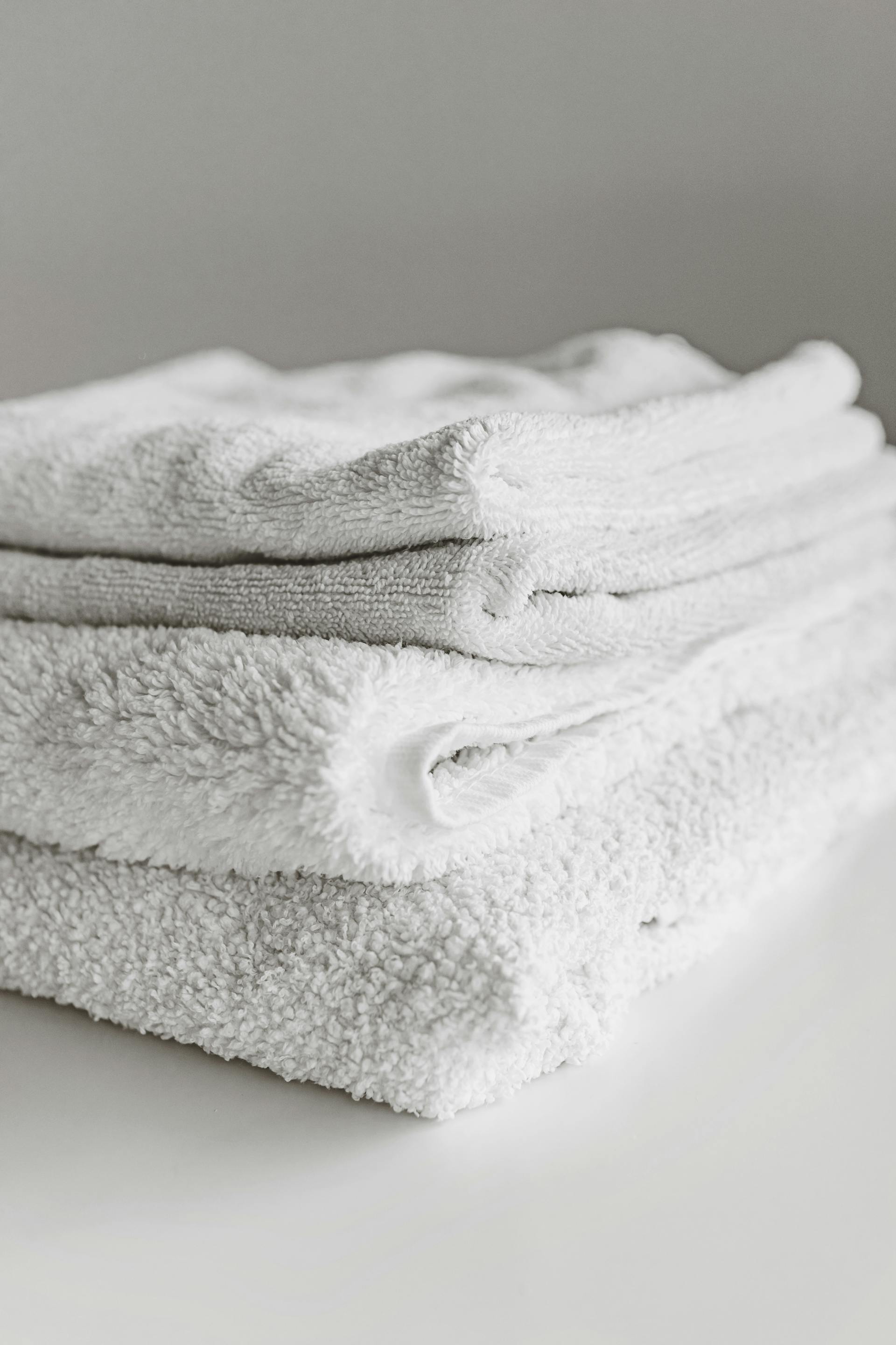 Stack of freshly folded white linen towels — Villa Sage